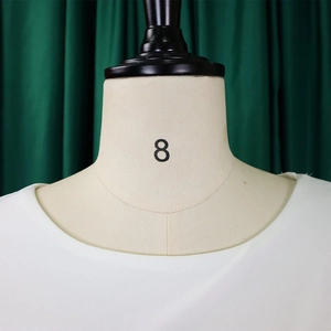 Détail de l'encolure ronde blanche en tissu texturé sur un mannequin de taille huit