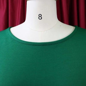 Detail of green ruffle-sleeve dress neckline with double-needle stitching on mannequin