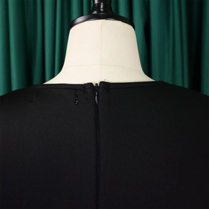 Détail de l'encolure dos avec fermeture éclair invisible sur une robe trapèze noire