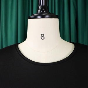 Détail de l'encolure ronde et des coutures raffinées de cette robe noire évasée en A