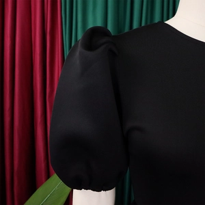 Détail des manches bouffantes noires élégantes avec structure plissée sur la robe de soirée