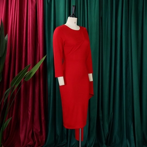 Détail d'une robe rouge à manches longues avec décolleté plissé asymétrique et coupe ajustée