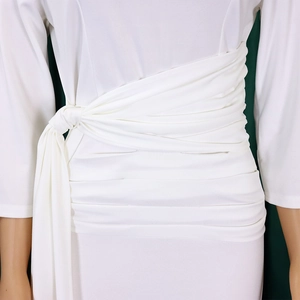 Detail showing elegant pleated waist tie design on a white long sleeve dress