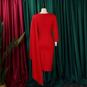 Détail d'une robe midi rouge moulante avec une longue écharpe d'épaule et fente au dos