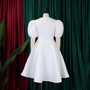 Détail d'une robe blanche à manches bouffantes avec col rond et fermeture éclair invisible