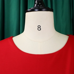 Détail de l'encolure ronde d'une robe rouge en tricot sur un mannequin de couture