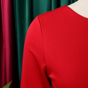 Gros plan de l'épaule d'une robe crayon rouge montrant la texture en maille et couture