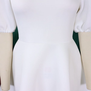 Détail d'une robe blanche à manches bouffantes et taille haute sur un mannequin