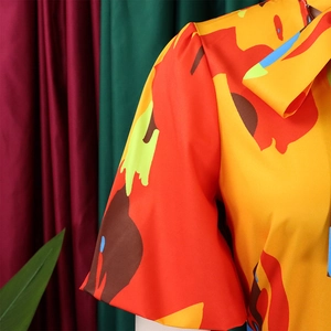Detail der lebhaften Bluse mit geometrischem Druck, Plissee-Puffärmeln und Bindeausschnitt