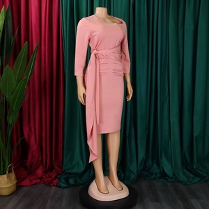 Detail of pink ruched dress featuring a wrap-around tie waist and elegant side ribbon