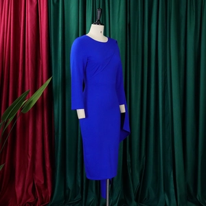 Détail d'une robe crayon bleu roi avec plis asymétriques et drapé de cape latéral