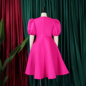 Dettaglio del retro del vestito rosa acceso con cerniera e maniche a sbuffo