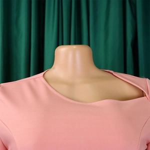 Detail of pink asymmetric neckline and shoulder cutout on a chic office dress