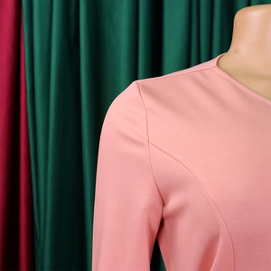 Close-up of pink round neck dress showing fine stitching and woven fabric texture