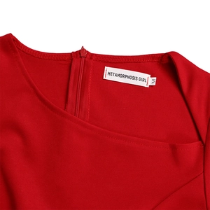 Detail view of the red dress neckline with a discreet invisible zipper and brand tag