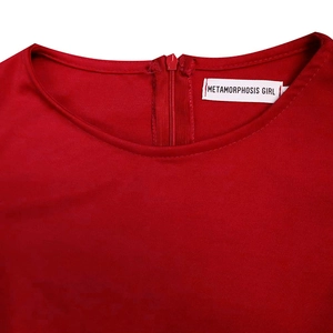 Detail of red crew neck dress featuring back zipper and metamorphosis girl label