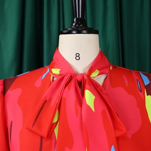 Details von rotem Hemdkragen mit großer Schleife und abstrakten Pop-Art-Druckmustern