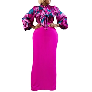 Dettaglio della camicia in chiffon floreale con fiocco e gonna lunga fucsia a vita alta