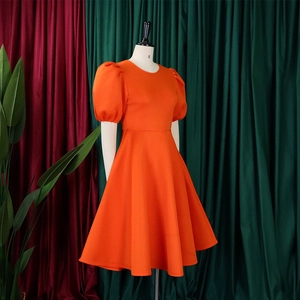 Dettaglio elegante abito arancione a trapezio con maniche a sbuffo e girocollo classico