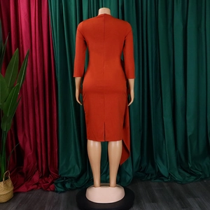 Detail of rust-orange midi dress showing slim fit cut and side slit on the skirt hem
