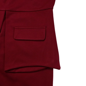 Detalle del vestido rojo oscuro mostrando el bolsillo con solapa y el tejido de punto