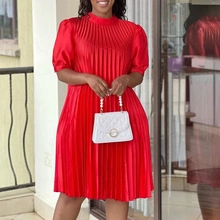 Detalle de vestido midi rojo plisado con mangas abullonadas y elegante cuello alto