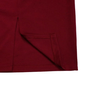 Detalle macro del dobladillo del vestido granate con costuras precisas y abertura lateral