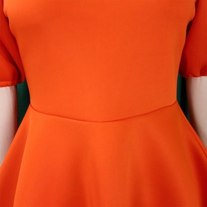 Dettaglio dell'elegante vestito arancione con vita alta e design a maniche a sbuffo