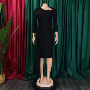Detail of black knee-length dress featuring asymmetric neckline and waist tie decoration