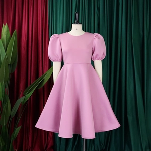Dettaglio dell'abito rosa con maniche a sbuffo e girocollo su un manichino sartoriale