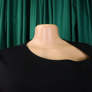 Close-up of the asymmetric neckline and smooth knit fabric on this elegant black dress