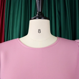 Dettaglio dello scollo rotondo e del tessuto rosa su un elegante abito a linea A