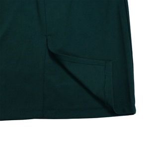 Detalle del dobladillo del vestido verde oscuro con abertura lateral y costura fina