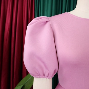 Dettaglio delle maniche a sbuffo rosa e trama in twill dell'elegante abito da sera