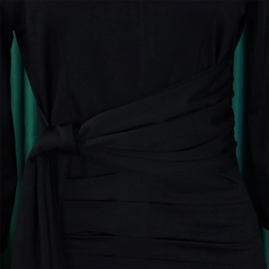 Detail of black dress featuring elegant side-tie waist and ruched texture fabric