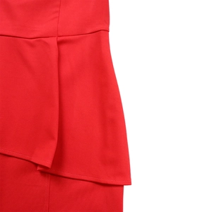Detail view of the red dress showing the layered peplum waist and high-quality stitching