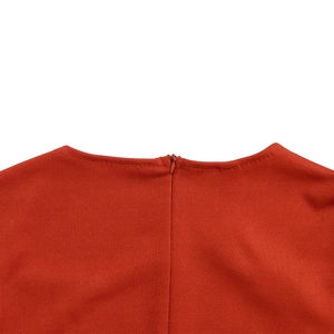 Close-up of the orange-red knit dress neckline featuring a seamless invisible zipper detail