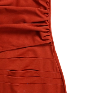 Close-up of ruched detail on a terracotta summer dress with textured pleats