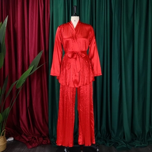 Detailansicht eines roten plissierten Satin-Sets mit Langarm-Oberteil und weiter Hose
