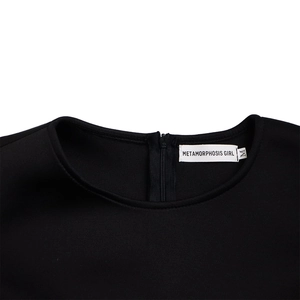 Détail de l'encolure robe noire avec col rond, fermeture éclair et étiquette de marque