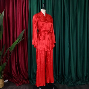 Makro-Detail des roten plissierten Satin-Loungewear-Stoffs mit Hochglanz-Finish