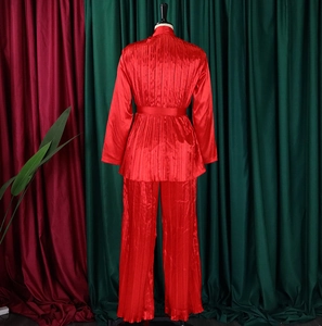 Detailansicht eines roten plissierten Satin-Zweiteilers mit Gürteltaille am Mannequin