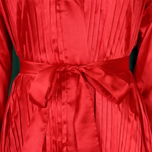Detailansicht der roten plissierten Satinbluse mit elegantem Bindegürtel an der Taille