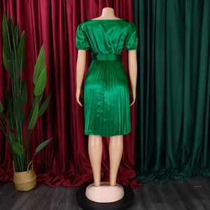 Rear view of green satin dress featuring a pleated skirt and matching wide waist belt
