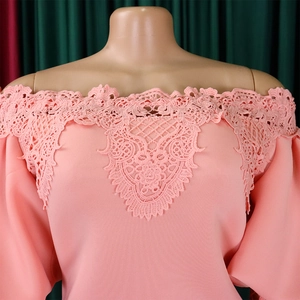 Detail of pink floral lace off-the-shoulder neckline and geometric cutout embroidery