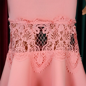 Detailed view of pink dress featuring intricate lace cutout and crochet floral waist embroidery