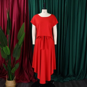 Detail of red two-piece maxi set featuring high-waisted belted skirt and round-neck top