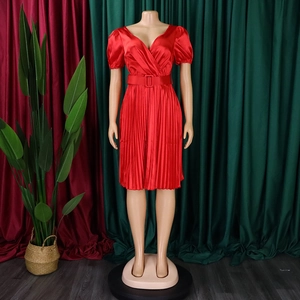 Detail of red V-neck pleated dress with satin texture and matching wide waist belt