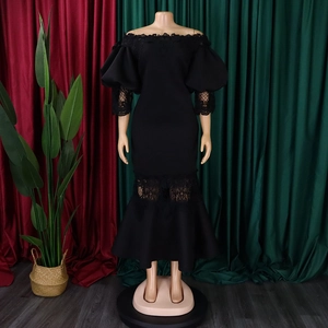Detailed view of the black lace patchwork off-shoulder neckline and puff sleeves on dress