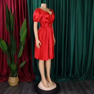 Close-up of red satin pleated dress with V-neck and a matching wide belt with buckle